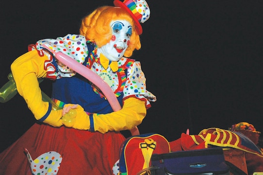 Cupcake T. Clown, balloon artist, prepares a balloon airplane at the Ho, Ho, Ho Down Dec. 16 on the station parade field. In addition to balloon art and face painting, attendees were also able to take part in pony rides, live music and free food as part of the festivities.