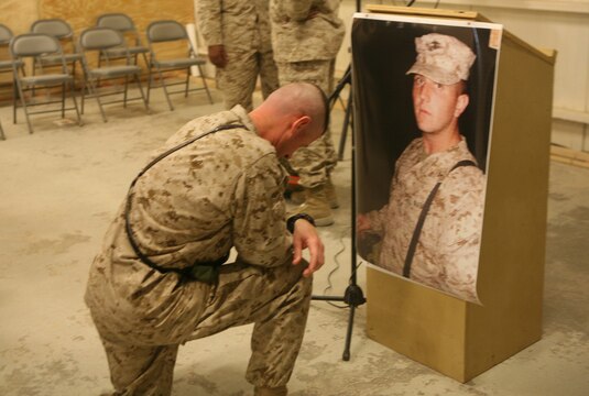 1st Sgt. Thomas A. Stone, 40, from Oceanside, Calif., first sergeant, Headquarters Battalion, Combat Logistics Battalion 5, pays his final respects to Lance Cpl. Robert L. Johnson, a 21-year-old motor transportation operator from Central Point, Ore.  Marines with Motor Transportation Company, CLB-5, 1st Marine Logistics Group, remembered Johnson, who died in a combat zone while serving here.