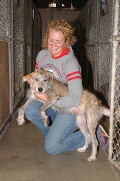 Angie Marchman, Single Marine Program coordinator, gives some much needed attention to Scruffy, pure mutt, inside the Humane Society of Yuma, Ariz., kennel Nov. 16. In case a family is looking for them, Scruffy and other strays brought to the society are held for three days before being eligible for adoption.