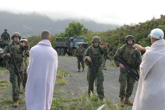 Marines with India Company, 3/3 attempt to stop Iraqi villagers, Marines from 81's Platoon, Weapons Company,  from coming closer to their vehicles during a training evolution Oct. 12 at Marine Corps Training Area Bellows. The villagers posed no threat to the Marines whose objective was to make communication with the village leader and gain information about possible weapons caches, insurgents and upcoming attacks. The village scenerio was one of several training missions the Marines participated in over the course of one day in order to prepare them for their upcoming deployment to Iraq.