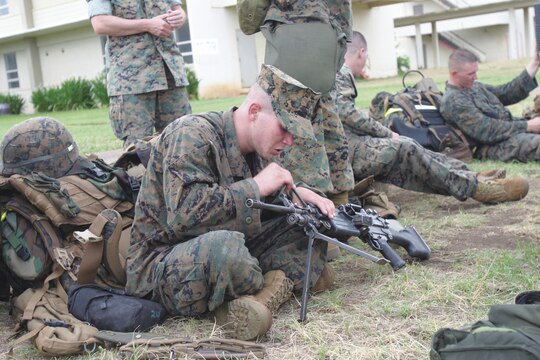 Pfc. Josh Sonnier, saw gunner, 2nd Platoon, Lima Company, 3/3, cleans his weapon after the hike from Marine Corps Training area Bellows, to K-Bay.  This was the first hike for Sonnier with Lima Company.