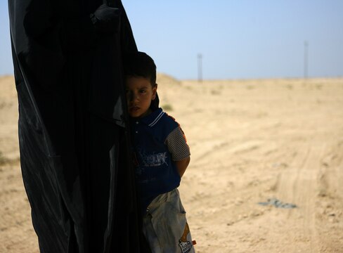 An Iraqi child clings to his mother?s clothes while Marines speak to his father through an interpreter.  Troops regularly carry candy to set Iraqi children at ease during routine vehicle stops. ?They treat (Iraqi?s) with respect, try to help them out in any way possible.  Offer water and food, ask them how their villages are doing, how their people are doing,? said Staff Sgt. Keith S. Littreal, a 29-year-old native of Greensboro, N.C. and the platoon sergeant of 1st Platoon, Military Police Company, Combat Logistic Regiment 15, 1st Marine Logistics Group (Forward). In the combat zone, MP Company provides security for vehicle/personnel recovery teams, supply trucks, and also scans supply routes for IEDs and enemy activity.