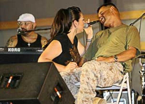Soto?s lead singer, Stephanie Alvarado serenades Navy Lt. Wilfredo Rodriguez, 46, from New Brunswick, N.J., the chaplain for the base?s Surgical Shock Trauma and Personnel Recovery platoons in Camp Taqaddum, Iraq. Despite the hot weather, and the band?s lead singer being administered intra-venous fluids to counter dehydration, the soulful ballads, Latin rhythms, and hot dance grooves that made up the high-energy concert held here, made it the coolest place to be on a Friday night. The Los Angeles based band Soto, performed for the troops live here August 12, 2006 as part of the Morale Welfare and Recreation program. ?We (service members) must thank MWR for doing this, it was nice to have a diverse crowd enjoying the music,? said Rodriguez.
