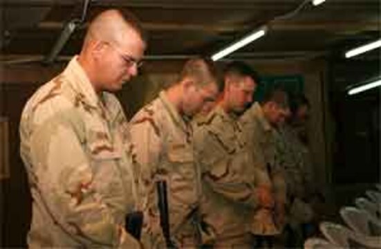 A moment of prayer is held in honor of two fallen sailors with Naval Mobile Construction Battalion 25, which gathered to remember its own in a memorial service held at the base chapel June 14, 2006. Members of the ?Seabee Family,? Petty Officer 1st Class Gary T. Rovinski, an equipment operator, and Petty Officer 2nd Class Jaime S. Jaenke, a corpsman, were killed June 5, 2006 by an improvised explosive device while their unit was convoying in the Al Anbar Province. A native of Roseville, Ill., Rovinksi is survived by his wife Jennifer and his two daughters, Cecilia, 13, and Michaela, 10. Jaenke, a native of Iowa Falls, Iowa, is survived by her parents Susan and Larry, and her daughter, Kayla, 9.
