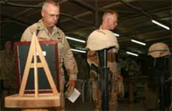 Personal moments of grief and remembrance are had by members of Naval Mobile Construction Battalion 25 during a memorial service held at the base chapel June 14, 2006, as the unit gathered to remember two of its own. Members of the ?Seabee Family,? Petty Officer 1st Class Gary T. Rovinski, an equipment operator, and Petty Officer 2nd Class Jaime S. Jaenke, a corpsman, were killed June 5, 2006 by an improvised explosive device while their unit was convoying in the Al Anbar Province. A native of Roseville, Ill., Rovinksi is survived by his wife Jennifer and his two daughters, Cecilia, 13, and Michaela, 10. Jaenke, a native of Iowa Falls, Iowa, is survived by her parents Susan and Larry, and her daughter, Kayla, 9.