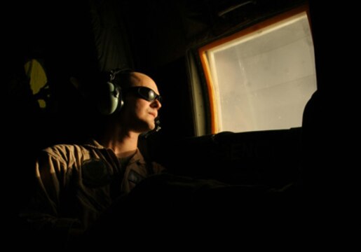 AL ASAD, Iraq - Cpl. Adam Palmer looks out the window of a KC-130J Hercules during an aerial refueling mission March 17, in Al Asad, Iraq. Palmer and other enlisted crewmembers with Marine Aerial Refueler Transport Squadrons 352, Marine Aircraft Group 16 (Reinforced), 3rd Marine Aircraft Wing, are responsible for safely conducting Marine aerial refueling missions throughout Iraq. Palmer is a loadmaster and West Palm Beach, Fla., native.