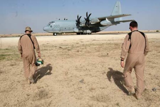 Sgt. James C. Curtis (left) and Cpl. Robert C. Lynall walk to a KC-130J Hercules before an aerial refueling mission at Al Asad, Iraq, March 17. Along with other enlisted crewmembers, the two Marines with Marine Aerial Refueler Transport Squadrons 352, Marine Aircraft Group 16 (Reinforced), 3rd Marine Aircraft Wing, are responsible for safely conducting Marine aerial refueling missions throughout Iraq. Curtis is a crew chief and Olympia, Wash., native. Lynall is a crew chief and Peoria, Ill., native.
