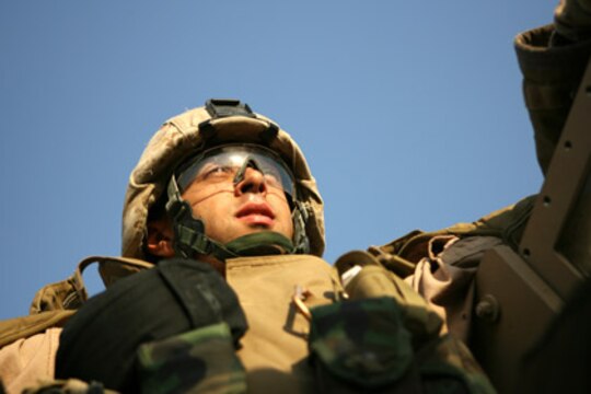Lance Cpl. Brandon Kjartansson, a 21-year-old native of Yonkers, New York, scans the Iraqi country side during a recent resupply mission conducted by Combat Logistics Detachment 115, June 25, 2006. The Marines of CLD 115 recently delivered three mobile kitchens to Camp Commando, a forward operating base occupied by the Iraqi Army and military advisors in the city of Ramadi. Logistics missions that support Iraqi forces have become more common as coalition forces focus on aiding in the construction of the new Iraqi Army.