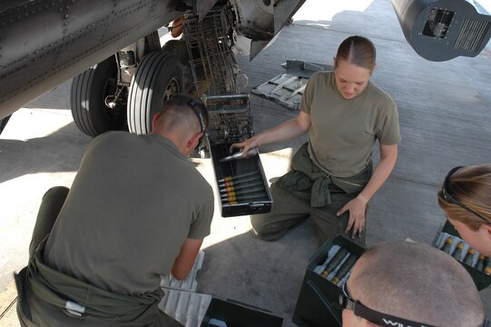 Lance Cpl. Elizabeth Daves (center), unloads rounds from the 25 mm gun on an AV-8B Harrier with other Marines from her ordnance shop in Al Asad, Iraq, July 10. Daves, with Marine Attack Squadron 513, Marine Aircraft Group 16 (Reinforced), 3rd Marine Air Wing, and the rest of the Marines in her ordnance shop are responsible for every piece of munitions that goes on every Harrier leaving Al Asad.