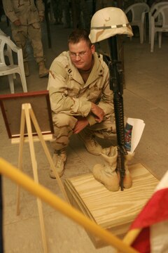 Navy Lt. Timothy V. Bray, a native of Crosslake, Minn., mourns one of his own, a fallen sailor, during a service July 21, 2006 for Petty Officer 1st Class Jerry A. Tharp, held at the Camp Taqaddum base chapel. Tharp, a Seabee with Naval Mobile Construction Battalion 25 and a native of Aledo, Ill., was killed in action while operating in the restive Al Anbar Province of Iraq July 12, 2006.