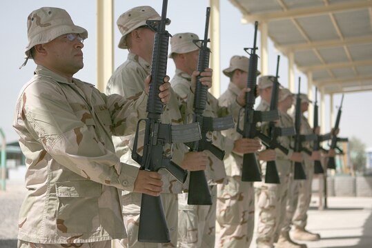 A rifle salute is performed for two fallen members of Naval Mobile Construction Battalion 25 during a memorial service held at the base chapel June 14, 2006. Members of the ?Seabee Family,? Petty Officer 1st Class Gary T. Rovinski, an equipment operator, and Petty Officer 2nd Class Jaime S. Jaenke, a corpsman, were killed June 5, 2006 by an improvised explosive device while their unit was convoying in the Al Anbar Province. A native of Roseville, Ill., Rovinksi is survived by his wife Jennifer and his two daughters, Cecilia, 13, and Michaela, 10. Jaenke, a native of Iowa Falls, Iowa, is survived by her parents Susan and Larry, and her daughter, Kayla, 9.