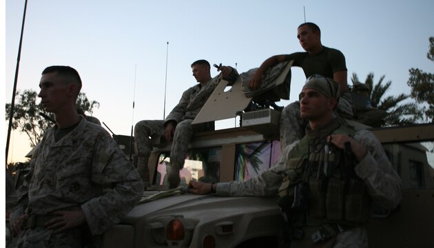Military police Marines with Combat Logistics Detachment 115 wait for the order to depart Camp Ramadi during a recent resupply mission. The Marines of CLD-115 delivered three mobile kitchens to Camp Commando, a forward operating base occupied by Iraqi army soldiers and U.S. military advisors. Logistics missions that support Iraqi forces have become more common as Coalition forces have shifted focus to developing the new Iraqi army.