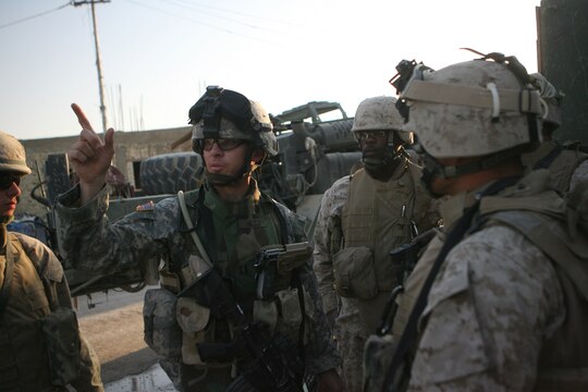 Marines listen as Capt. John P. Hiltz, a company commander with 40th Engineer Battalion, gives instructions at Combat Outpost Falcon shortly after they arrived to emplace over 300 concrete barriers June 26, 2006. The five Marines, a part of Combat Logistics Detachment 115, Combat Logistics Regiment 15, out of Camp Taqaddum, Iraq, aided the Army's 1st Brigade, 1st Armored Division in securing the combat outpost, a part of increased security operations in Southern Ramadi. (Official USMC photograph by Cpl. Daniel J. Redding. 060626-M-7799R-003. Released.)