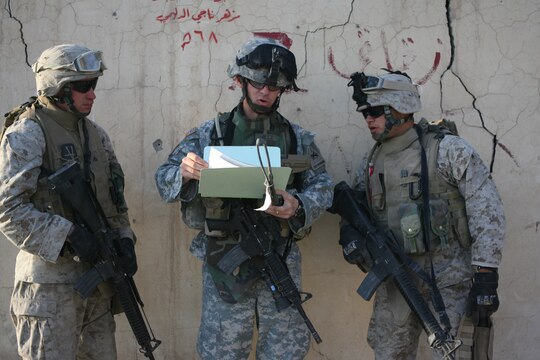Marines listen as Capt. John P. Hiltz, a company commander with 40th Engineer Battalion, gives instructions at Combat Outpost Falcon shortly after they arrived to emplace over 300 concrete barriers June 26, 2006. The five Marines, a part of Combat Logistics Detachment 115, Combat Logistics Regiment 15, out of Camp Taqaddum, Iraq, aided the Army's 1st Brigade, 1st Armored Division in securing the combat outpost, a part of increased security operations in Southern Ramadi. (Official USMC photograph by Cpl. Daniel J. Redding. 060626-M-7799R-004. Released.)