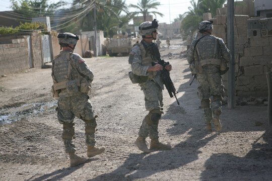 Soldiers with Task Force 1st Battalion, 37th Infantry Regiment patrol the interior of Combat Outpost Falcon June 26, 2006. Five Marines, a part of Combat Logistics Detachment 115, Combat Logistics Regiment 15, out of Camp Taqaddum, Iraq, arrived here to aid the Army's 1st Brigade, 1st Armored Division in securing the combat outpost, a part of increased security operations in Southern Ramadi. (Official USMC photograph by Cpl. Daniel J. Redding. 060626-M-7799R-006. Released.)