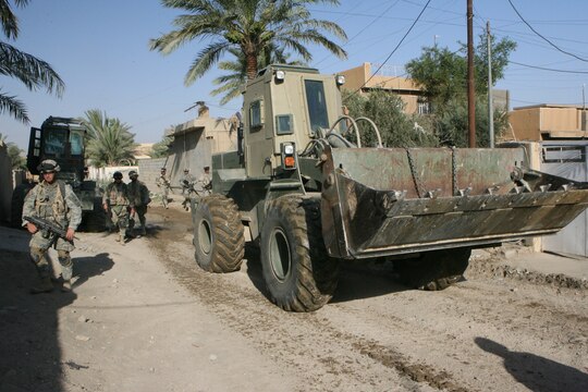 Marines and soldiers at Combat Outpost Falcon utilize an up-armored forklift, commonly referred to as a TRAM, to emplace over 300 concrete barriers June 26, 2006. The five Marines, a part of Combat Logistics Detachment 115, Combat Logistics Regiment 15, out of Camp Taqaddum, Iraq, aided the Army's 1st Brigade, 1st Armored Division in securing the combat outpost, a part of increased security operations in Southern Ramadi. (Official USMC photograph by Cpl. Daniel J. Redding. 060626-M-7799R-012. Released.)
