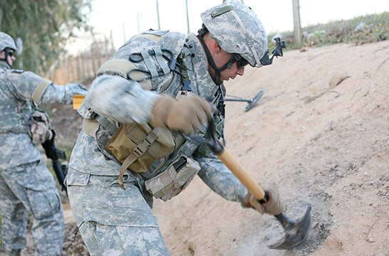 Sgt. Robert R. Anderson, infantryman, digs for a suspected weapons cache in a village near Camp Taqaddum, Iraq, March 12th, 2006. Anderson, 25, a native of Gillespie, Ill., and the other soldiers from 2nd Battalion, 130th Infantry Regiment, performed a multi-faceted mission during the daylong operation as they carried out weapons cache sweeps, investigated possible improvised explosive devices and conducted route clearance operations. The Illinois-based National Guard took a few moments throughout the day to assist Iraqi villagers in the area, handing out supplies and spending time with the local children. The soldiers were grateful it wasnâ??t business as usual and could do something a little light hearted. Whether itâ??s handing out candy or searching for IEDs, the soldiers are proud of what they are doing in Iraq, said Sgt. 1st Class Timothy J. Atteberry, platoon sergeant. â??The individual, personal satisfaction of helping another human being really comes from these kinds of humanitarian-aid type missions,â? said Atteberry, a 38-year-old native of Champagne, Ill.::n::::n::The soldiersâ?? primary mission is to provide base security for the Marines and sailors of the forward-deployed 1st Marine Logistics Group. The 4,200 joint-service members of 1st MLG are part of the 25,000 Marines, airmen, solders and sailors of the 1st Marine Expeditionary Forceâ??s forward deployed element. The 1st MLGâ??s mission is to provide sustained logistics support to I MEF and Iraqi security forces operating in the Al Anbar province of Iraq. First MLG will also support the development of the Iraqi Security Forces' logistic capabilities in order to enable independent ISF led counter insurgency operations.::n::