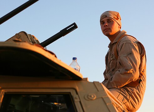 Spec. Brian R. Sterthi, infantryman, takes a moment to collect himself as he and his fellow soldiers prepare to head out on a convoy March 12, 2006, near Camp Taqaddum, Iraq. Sterthi, 21, of Lagrange, Ill., and the soldiers of 2nd Battalion, 130th Infantry Regiment, performed a multi-faceted mission during the daylong operation, as they carried out weapons cache sweeps, investigated possible improvised explosive devices and conducted route clearance operations. The Illinois-based National Guard took a few moments throughout the day to assist Iraqi villagers in the area, handing out supplies and spending time with the local children. The soldiers were grateful it wasnâ??t business as usual and could do something a little light hearted. Whether itâ??s handing out candy or searching for IEDs, the soldiers are proud of what they are doing in Iraq, said Sgt. 1st Class Timothy J. Atteberry, platoon sergeant. â??The individual, personal satisfaction of helping another human being really comes from these kinds of humanitarian-aid type missions,â? said Atteberry, a 38-year-old native of Champagne, Ill.::n::::n::The soldiersâ?? primary mission is to provide base security for the Marines and sailors of the forward-deployed 1st Marine Logistics Group. The 4,200 joint-service members of 1st MLG are part of the 25,000 Marines, airmen, solders and sailors of the 1st Marine Expeditionary Forceâ??s forward deployed element. The 1st MLGâ??s mission is to provide sustained logistics support to I MEF and Iraqi security forces operating in the Al Anbar province of Iraq. First MLG will also support the development of the Iraqi Security Forcesâ?? logistic capabilities in order to enable independent ISF led counter insurgency operations.