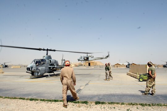 Marines with the ordnance division, Marine Light Attack Helicopter Squadron 369, Marine Aircraft Group 16 (Reinforced), 3rd Marine Aircraft Wing, stand ready to disarm an AH-1W Super Cobra as it settles down on its skids at Al Taqaddum, Iraq, March 25.