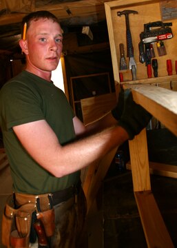Lance Cpl. Thomas R. Hunter looks down a piece of lumber to make sure it is straight May 13, 2006, at Al Asad, Iraq, while building a bench for his 'Gurus' woodshed. Hunter, a native of Tacoma, Wash., is a combat engineer with Marine Wing Support Squadron 373, Marine Wing Support Group 37 (Reinforced), 3rd Marine Aircraft Wing. Hunter is augmented to Marine Wing Headquarters Squadron 3 for the duration of his deployment and serves as an engineer operations clerk.