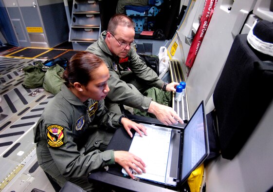 Staff Sgt. Joleen Manuia and Master Sgt. Mike Cumberland review publications before departing from Hickam Air Force Base, Hawaii, on Thursday, May 25, 2006. Sergeant Manuia is with the Hawaii Air National Guard's 204th Airlift Squadron. Sergeant Cumberland is with the 535th AS at Hickam. Both are C-17 Globemaster III loadmasters. They are two of the Air Force crew members helping move equipment and troops from the Solomon Islands to Australia, repositioning Australian Defense Forces to support peace operations in East Timor. (U.S. Air Force photo/Tech. Sgt. Shane A. Cuomo) 
