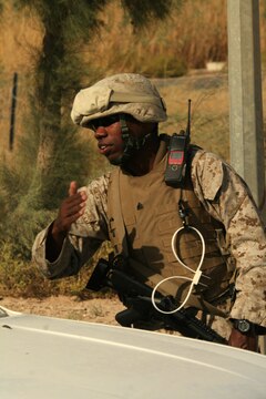 Sgt. Justin A. Hauser signals a vehicle to enter the Tactical Air Command Center compound at Al Asad, Iraq, Sept. 21. Hauser is the sergeant of the guard with TACC Security, Alpha Battery, 3rd Low Altitude Air Defense Battalion, Marine Wing Support Group 37 (Reinforced), 3rd Marine Aircraft Wing (Forward). He is a 28-year-old native of Albany, N.Y.
