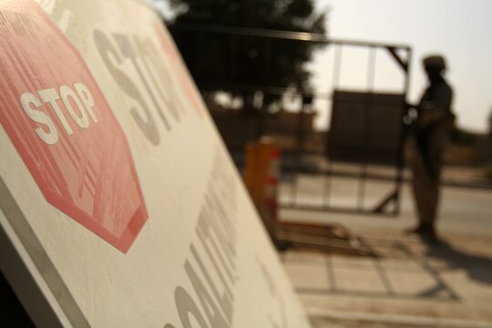 A sign sits next to the security gate of the Tactical Air Command Center compound, telling people to stop before entering the compound.