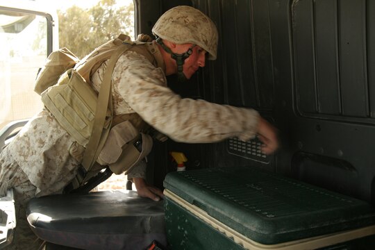 Cpl. Ian H. Petri searches the inside of a vehicle entering the Tactical Air Command Center compound at Al Asad, Iraq, Sept. 21. Petri is the corporal of the guard with TACC Security, Alpha Battery, 3rd Low Altitude Air Defense Battalion, Marine Wing Support Group 37 (Reinforced), 3rd Marine Aircraft Wing (Forward). He is a 19-year-old native of West Windsor, N.J.