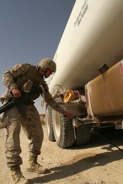 Cpl. Ian H. Petri searches the underside of a vehicle entering the Tactical Air Command Center compound with a mirror at Al Asad, Iraq, Sept. 21. Petri is the corporal of the guard with TACC Security, Alpha Battery, 3rd Low Altitude Air Defense Battalion, Marine Wing Support Group 37 (Reinforced), 3rd Marine Aircraft Wing (Forward). He is a 19-year-old native of West Windsor, N.J.