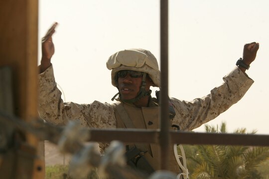 Sgt. Justin A. Hauser signals for one vehicle to halt and another to proceed through the gate of the Tactical Air Command Center compound at Al Asad, Iraq, Sept. 21. Hauser is the sergeant of the guard with TACC Security, Alpha Battery, 3rd Low Altitude Air Defense Battalion, Marine Wing Support Group 37 (Reinforced), 3rd Marine Aircraft Wing (Forward). He is a 28-year-old native of Albany, N.Y.