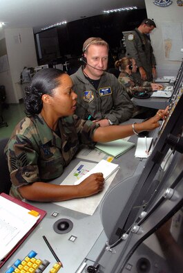 Tech. Sgt. Connie Brent and Maj. Charles Dennison of Kadena Air Base's 623rd Air Control Flight control a large force exercise using the Base Air Defense Ground Environment system at Naha Air Base, Japan. A tactical control operations team, made up of 10 unit members consisting of officers, controllers and technicians who provide battle management for Kadena's F-15 sorties, will receive a mission plan brief at their unit before travelling 20 miles to Naha each flying day. (U.S. Air Force photo/Staff Sgt. Steven Nabor)