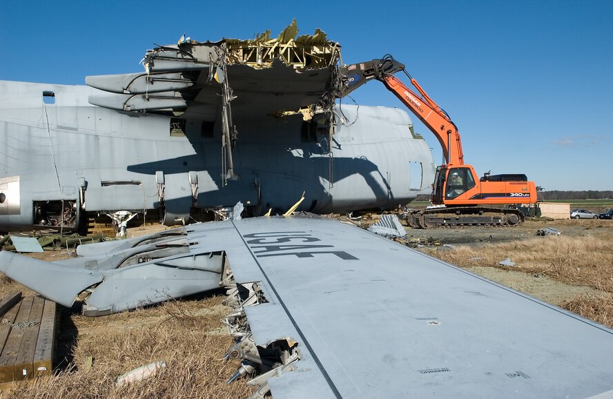 InterGroup International, an Ohio-based company that buys, reprocesses and sells scrap metal, cuts the wings off of the April 3, 2006 C-5 mishap aircraft at Dover Air Force Base, Del.,using giant mobile shears Jan. 17. (U.S. Air Force Photo/Jason Minto)