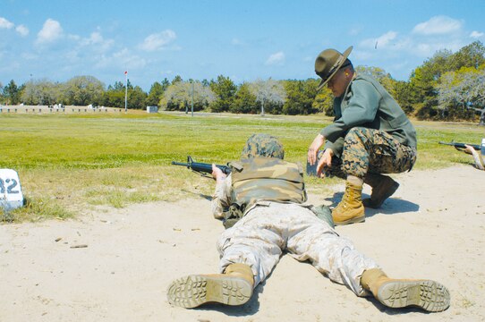Sergeant Rusty Jones, primary marksman instructor, Marksmanship Training Unit, observes a Marine as he fires from the 300 yard line March 29.