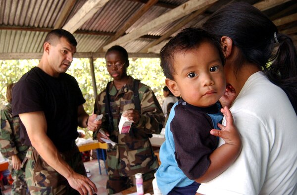 Master Sgt. Alvaro Magana, left, and Staff Sgt. Natasha Johnson explain to a mother the recommended dosage for her son while dispensing medication during a Medical Readiness Training Exercise June 29 in El Horno, Honduras. Sergeants Magana and Johnson are both from the Medical Element at Soto Cano Air Base, Honduras. (U.S. Air Force photo/Tech. Sgt. Sonny Cohrs) 
         