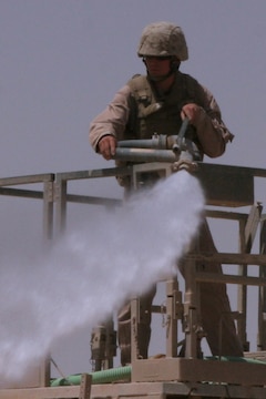 A Marine with Marine Wing Support Squadron 172, 3rd Marine Aircraft Wing (Forward), sprays a layer of "rhino snot" on to the deck during the recent construction of a helicopter-landing zone. A key step in the construction and improvement of HLZs, the substance is a soil-stabilizer which hardens the dirt, preventing excessive kick-up when aircraft land.