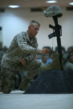 CAMP FALLUJAH, Iraq (August 16, 2008) - Cpl. Christopher L. Riley, a small arms repair technician with Maintenance Company, Combat Logistics Battalion 1, 1st Marine Logistics Group, pays final respects to his friends, Cpls. Adam T. McKiski and Stewart S. Trejo, during the memorial service at Camp Fallujah Aug. 16. Riley, from Columbia, Mo., was one of six Marines who served on the memorial detail. “I’m honored to do it,” the 21-year-old said. “It’s the least I can do for them.”  Both Marines were known for their outgoing personalities and helpful attitudes by their fellow Marines. (Photo by Cpl. Tyler B. Barstow)