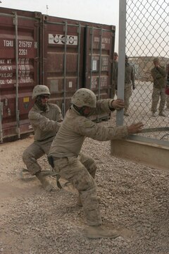Marines with Transportation Support Company, Combat Logistics Battalion 2, 1st Marine Logistics Group, maneuver a refrigerated container into place while it?s suspended in air by a 25-ton crane here Dec. 21. Marines and Sailors with TS Co., CLB-2, 1st MLG play a vital role in providing logistical support for the military, police and border transition teams in western al Anbar province. ?It?s imperative that we get (3rd Bn., 7th Marine Regiment, Regimental Combat Team 5) the supplies they need for them to be mission capable,? said 1st Lt. Aaron L. Serrano, 28, Carlisle, Iowa, convoy commander, TS Co., CLB-2, 1st MLG. Marines with 3/7 are working everyday to develop the local economy and government in the area. ?We conduct leadership engagements with Iraqi Police chiefs, school headmasters, and city council members,? said 1st Lt. John A. Meyer, 26, Keller, Texas, executive officer, Co. K, 3/7. ?We give them guidance and advice to function as a community.?