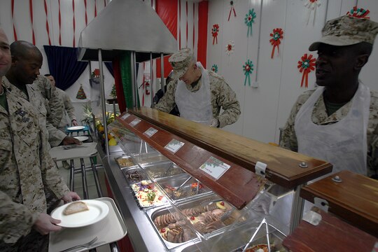 General James T. Conway, Commandant of the Marine Corps, and Sergeant Major Carlton W. Kent, Sergeant Major of the Marine Corps, serve dinner at a dining facility here Dec. 25. Conway and Kent talked to Marines about the growth of the Corps and the Corps? anticipated shift to Afghanistan during a ?town hall? meeting earlier in the night.