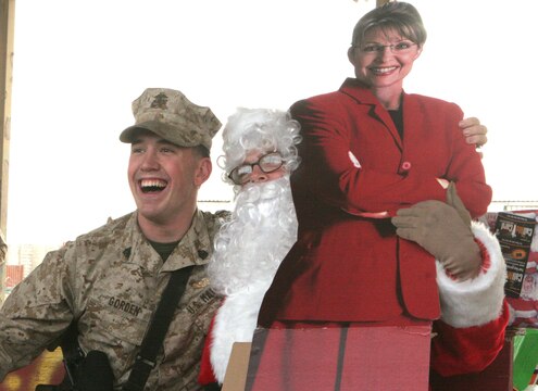 Cpl. Joshua T. Rogers, 21, Sedalia, Mo., heavy equipment operator, Transportation Security Company, Combat Logistics Battalion 2, 1st Marine Logistics Group, receives a present from Santa Claus here Dec. 25. Two-hundred and fifteen Marines and Sailors each received a gift that was donated by family members and friends of the family of Capt. Tim P. Maloney, commanding officer, TS Co., CLB-2, 1st MLG. ?Being away from friends, family and home isn?t easy,? said Maloney, 30, Milton, Mass. ?To brighten up their Christmas, my wife Christina started coordinating and collecting donated gifts to send out here to the Marines and Sailors.? The platoon commanders of TS Co. collected a wish list from their troops to send back to the U.S. in November so the present would make it here by Christmas. ?Overall it shows that the people back home still truly care about the service members and what they do for our country.?