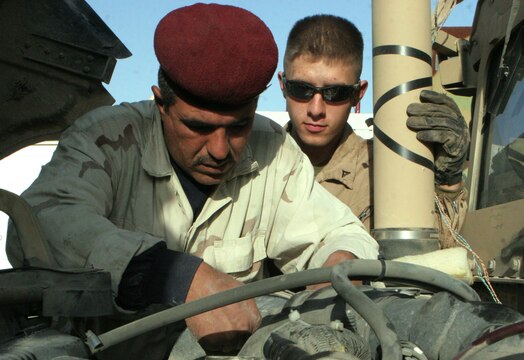 Cpl. Jaimey C. Syvruv, motor transportation mechanic, Combat Logistics Battalion 2, 1st Marine Logistics group, helps an Iraqi Soldier trouble shoot a heater problem on a High-Mobility, Multipurpose, Wheeled Vehicle during the first Iraqi partnership at the Iraq camp here, Dec. 31. ?This is the first time we worked with Iraqi Soldiers at their camp instead of our maintenance area,? said Gunnery Sgt. Duane E. Black, 38, Marceline, Mo., Motor Transportation Maintenance Platoon commander, CLB-2, 1st MLG. ?We can train more of their mechanics at the Iraqi maintenance bay because they all can?t come over to our shop.? For more than a year, Iraqi mechanics on Camp Majed aboard Al Asad have been traveling to the American side of the base for HMMWV mechanical training. No more then five Iraqi Soldiers would show up every Wednesday to learn about fixing their military vehicles. Over the last year, the Primary Iraqi Command has been focusing on Marines standing back and advising instead of fixing the vehicles for them. ?We?re here to watch over the Iraqi Soldiers and observe them work on HMMWV,? said Syvruv, 22, Blanchardville, Wis. ?We are standing back and letting them do the work so they can become more self sufficient.? With all the mechanical knowledge the Marines taught to the Iraqi Soldiers, U.S. forces will be able to leave Iraq knowing they can function as a military on their own.