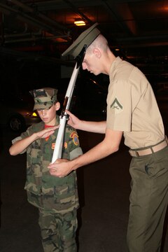 Lance Cpl. Jake Summerton instructs Young Marine Pvt. Robert Jackson on ceremonial drill at Marine Barracks Washington, July 18. Summerton is a member of the Marine Corps Color Guard and performs in hundreds of ceremonies each year.