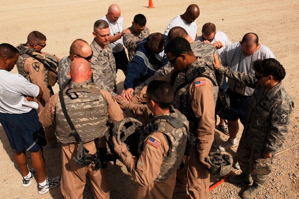SOUTHWEST ASIA -- Airmen from the 586th Expeditionary Logistics Readiness Squadron, 70th Medium Truck Detachment, bow their heads during a prayer before heading out on a recent convoy from an Army camp in the Persian Gulf Region. The Airmen of the 70th and 424th MTDs assigned to the 586th ELRS are in-lieu-of forces supporting the Army Support Line-Haul Convoy movements in and out of Iraq.  (U.S. Air Force photo/ Staff Sgt. Patrick Dixon)