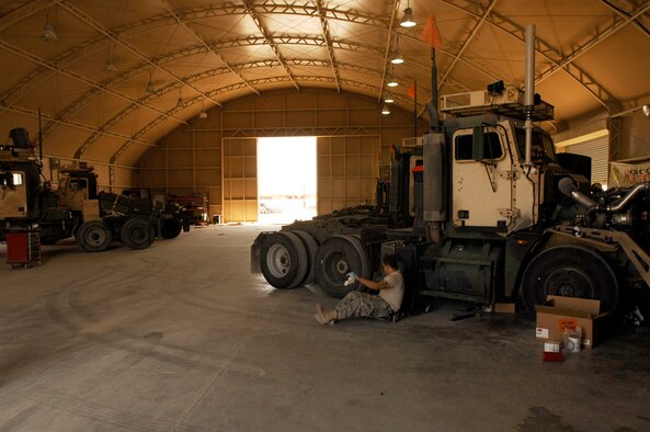 SOUTHWEST ASIA -- Senior Airman Lesther Lopez, a vehicle maintainer deployed to the 586th Expeditionary Logistics Readiness Squadron, 70th Medium Truck Detachment, prepares to slide up under a M915A3 tractor-trailer truck during scheduled maintenance recently at an Army camp in the Persian Gulf Region. The Airmen of the 70th and 424th MTDs assigned to the 586th ELRS are in-lieu-of forces supporting the Army Support Line-Haul Convoy movements in and out of Iraq. Airman Lopez is deployed from the 97th Logistics Readiness Squadron, Altus Air Force Base, Okla. (U.S. Air Force photo/ Staff Sgt. Patrick Dixon)