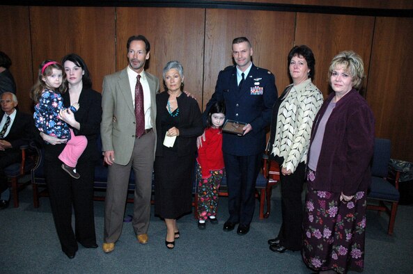 Maj. Phil Heseltine, U.S. Air Force Expeditionary Center executive officer to the commander, Fort Dix, N.J., holds a POW/MIA bracelet he wore for 18 years bearing the name of Maj. Robert F. Woods, as he stops for a photo with his family and the Woods family during the funeral for Major Woods at Arlington National Cemetery April 9, 2008.  (U.S. Air Force Photo/Tech. Sgt. Scott T. Sturkol)