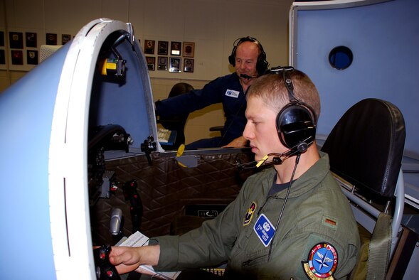 Second Lt. Evan Negron, a T-37 Tweet student pilot in the Euro-NATO Joint Jet Pilot Training Program at Sheppard Air Force Base, Texas, "flies" the last simulation by a student pilot in the Air Force April 23. The T-6A Texan II will replace the Tweet this summer when the more than 50-year-old introductory trainer retires. Also pictured (blue flight suit) is Wolfgang Ruhl, a simulator instructor at Sheppard. Mr. Ruhl has trained every ENNJPT class since the organization was formed in 1981. (U.S. Air Force photo/John Ingle) 