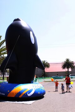 A mother calls to her sons as they stare at a towering Shamu ballon at the ITT Latitudes & Travel Expo at Camp Pendleton, Aug. 14. Camp Pendleton service members and their families received free food, gifts, activities and information from a variety of entertainment services.