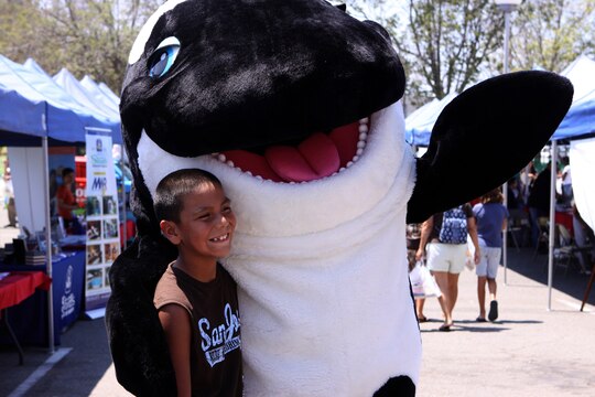 Clayvin B. Tendore, 8, poses for a picture with Shamu at the ITT Latitudes & Travel Expo, Aug. 14.