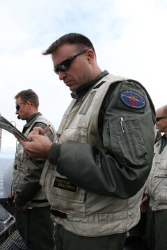 Capt. Brent W. Stevens, an instructor pilot with Marine Fighter Attack Training Squadron 101, Marine Aircraft Group 11, 3rd Marine Aircraft Wing, I Marine Expeditionary Force, critiques a fleet replacement pilot's landing with a F/A-18C "Hornet" while conducting carrier qualifications aboard the USS John C. Stennis, Dec. 10. The instructors grade the pilot's approach and landing evaluating how they maneuver the Hornet during the training.