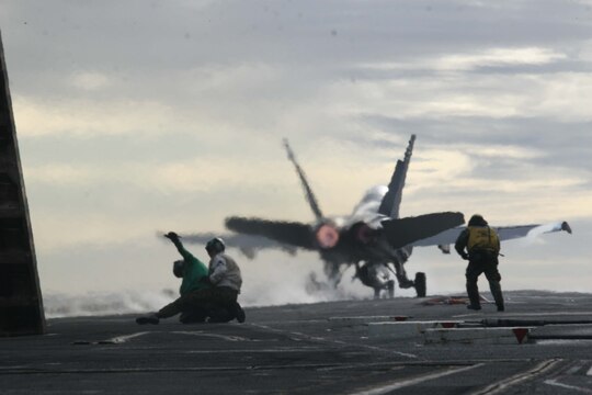Final checkers and other personnel aboard the flight deck of the USS John C. Stennis prepare to help launch another F/A-18 "Hornet" belonging to Marine Attack Training Squadron 101, after the ship's steam powered catapult launched the aircraft from 0 to 165 mph in two seconds, Dec. 10. Marines and sailors from VMFA(T)-101, Marine Aircraft Group 11, 3rd Marine Aircraft Wing, I Marine Expeditionary Force, maintain F/A-18 "Hornet" models ranging from A through D.  (Official U.S. Marine Corps photo by Cpl. Christopher O'Quin)(Released)
