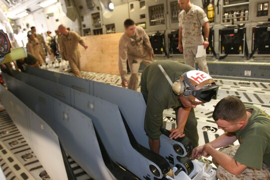 Staff Sgt. Travis R, Samons, a UH-1Y "Venom" crew chief with Marine Light Attack Helicopter Squadron 367, Marine Aircraft Group 39, 3rd Marine Aircraft Wing, I Marine Expeditionary Force, fastens its main rotor blades aboard a C-17 "Globemaster" III for transport to Afghanistan aboard Marine Corps Air Station Camp Pendleton, Oct. 20. The Marines worked with loadmasters from the 729th Airlift Squadron, based at March Air Force Base, secure a winch for loading the aircraft aboard the Globemaster.  (Official U.S. Marine Corps photo by Cpl. Christopher O'Quin)(Released)